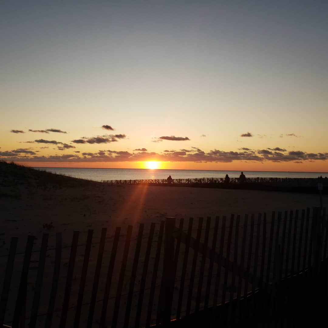 Two friends laughing together on the beach in Provincetown