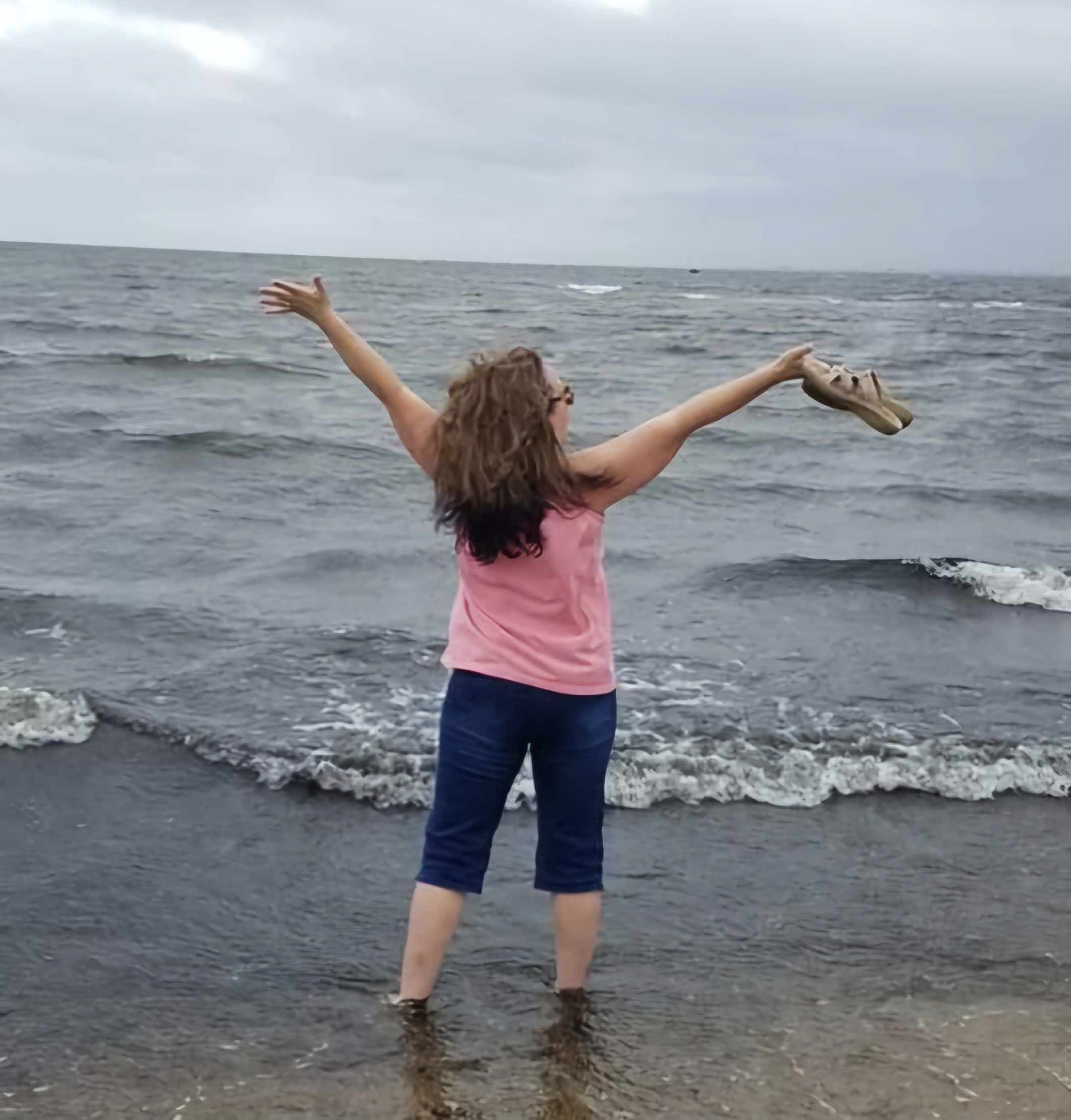 Arms wide open in the surf on a grey Cape Cod morning